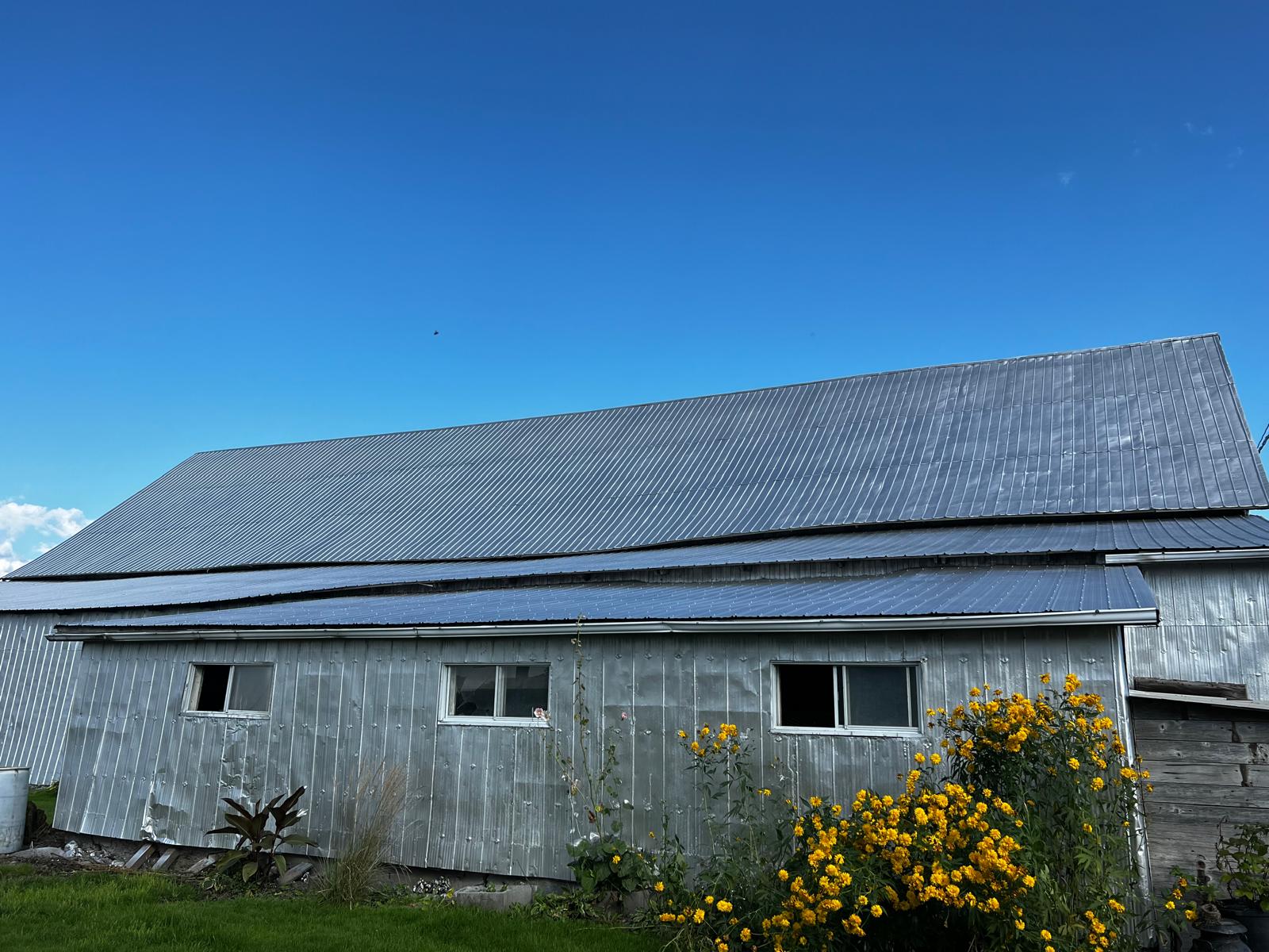 Grange toiture tôle peinte ciel bleu Québec